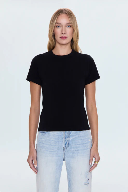 Front view of woman in black cotton T-shirt and light jeans