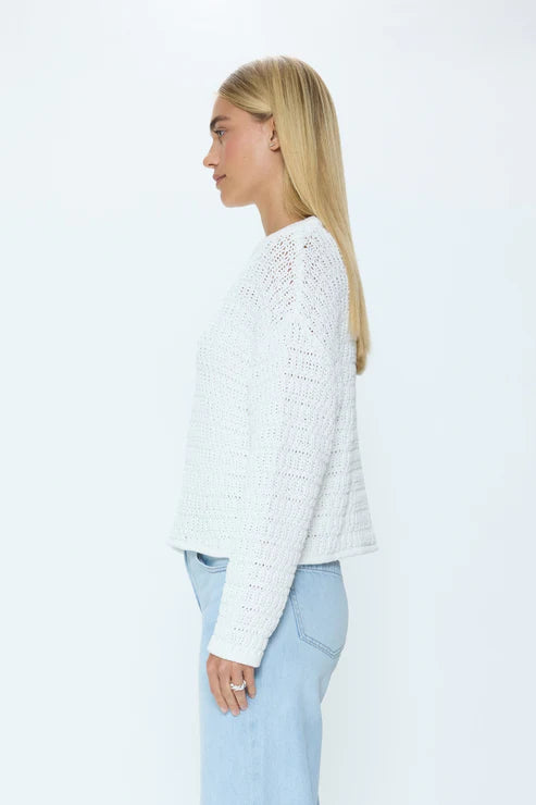 Side view of white knit crew neck sweater on model
