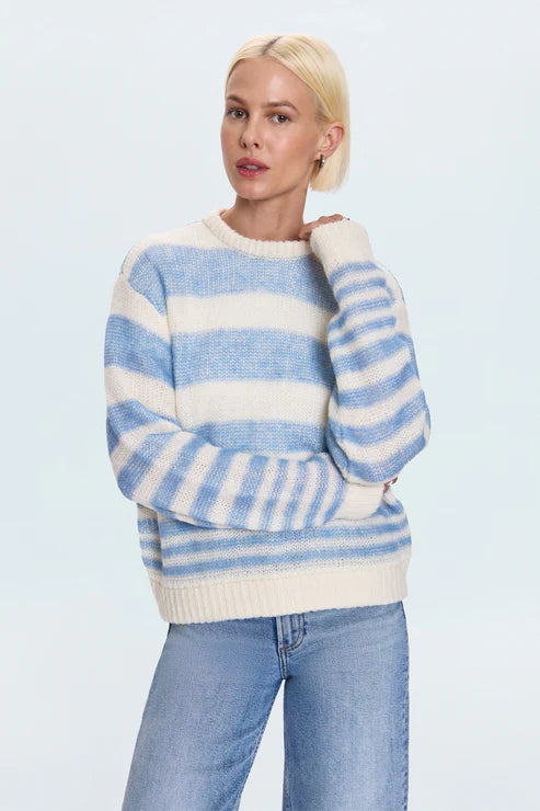 Model wearing blue and white striped knit sweater with jeans