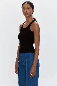 Model wearing black curved hem tank top with blue jeans
