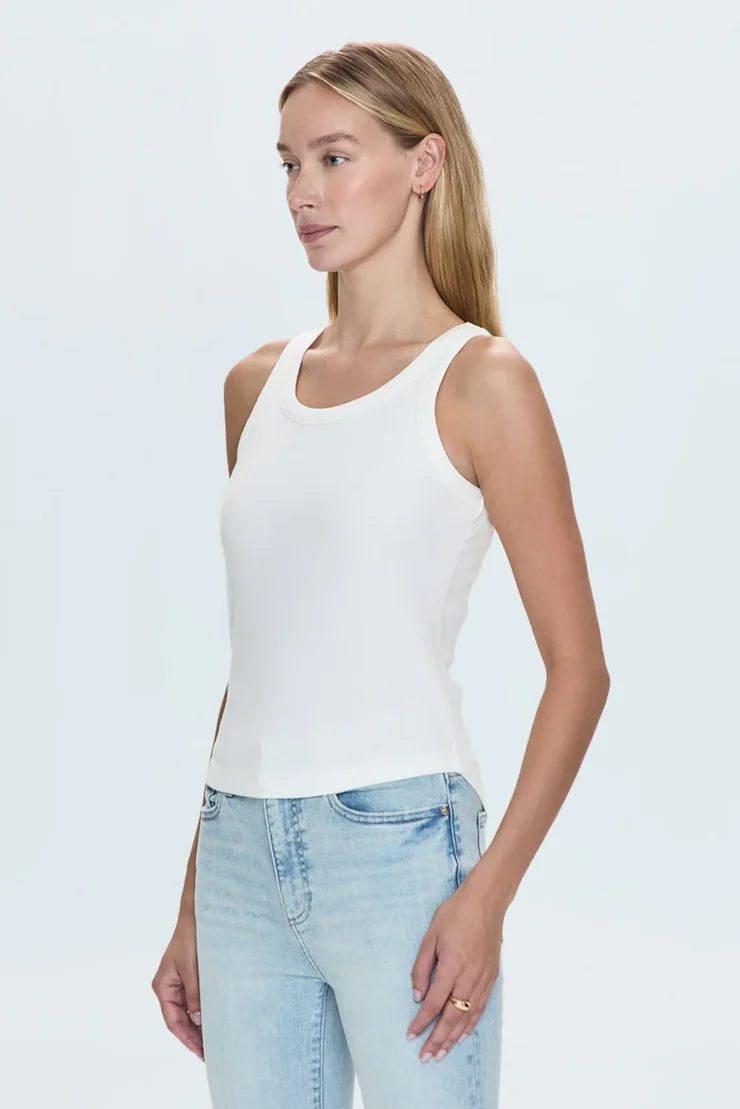 Model wearing white tank top with jeans for versatile look